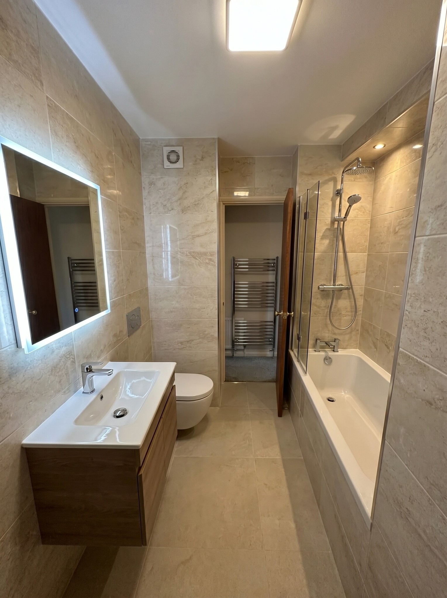 Finished bathroom renovation with bath and shower screen