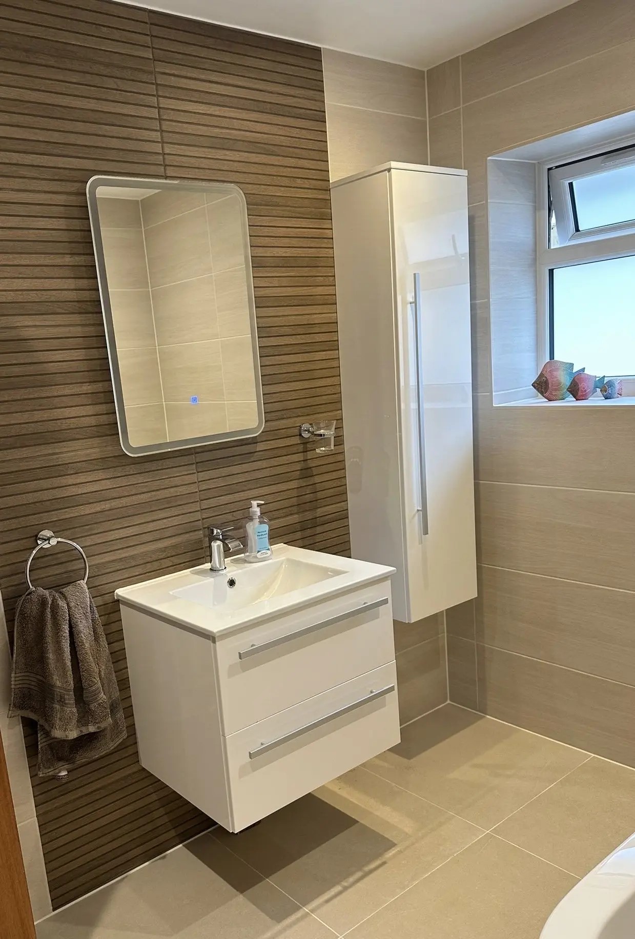 Finished bathroom vanity area with wood-effect feature tiles and wall mirror